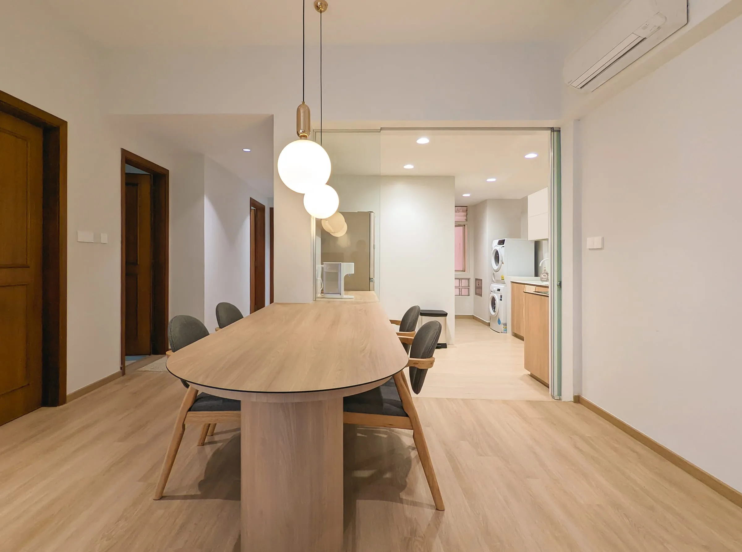 Dining area with an oval timber table and globe pendant lights