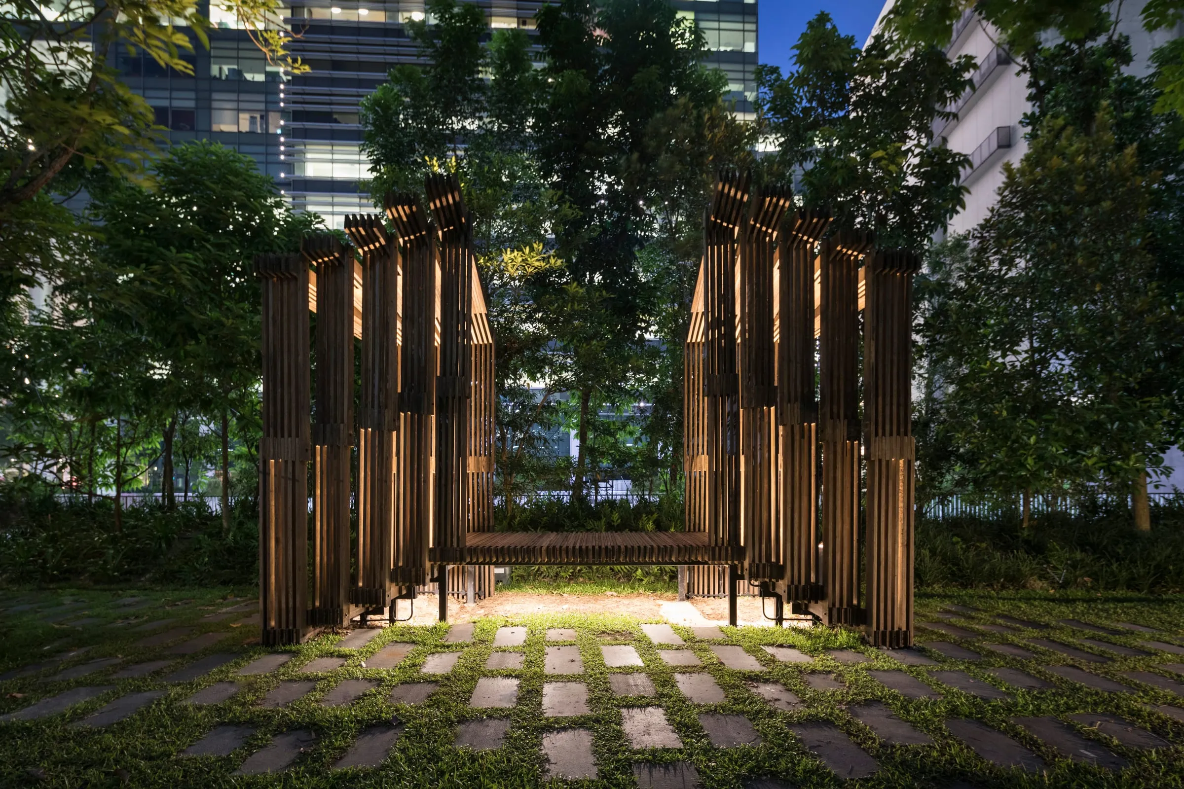 Sundial Structure, a slatted timber pavilion at Mapletree Business City, at dusk
